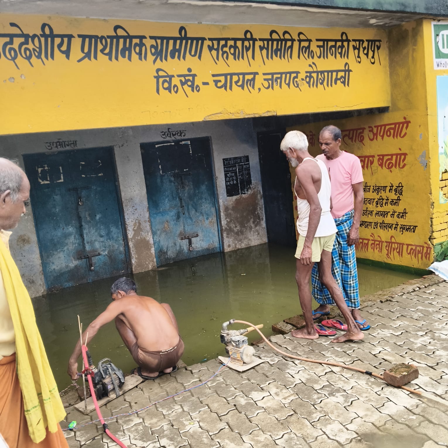 पानी में डूबी गोदाम के भीतर रखी उर्वरक, बिजली की मोटर पंप से पानी निकालते ग्रामीण। संवाद, पानी में डूबी गोदाम के भीतर रखी उर्वरक, बिजली की मोटर पंप से पानी निकालते ग्रामीण। संवाद,