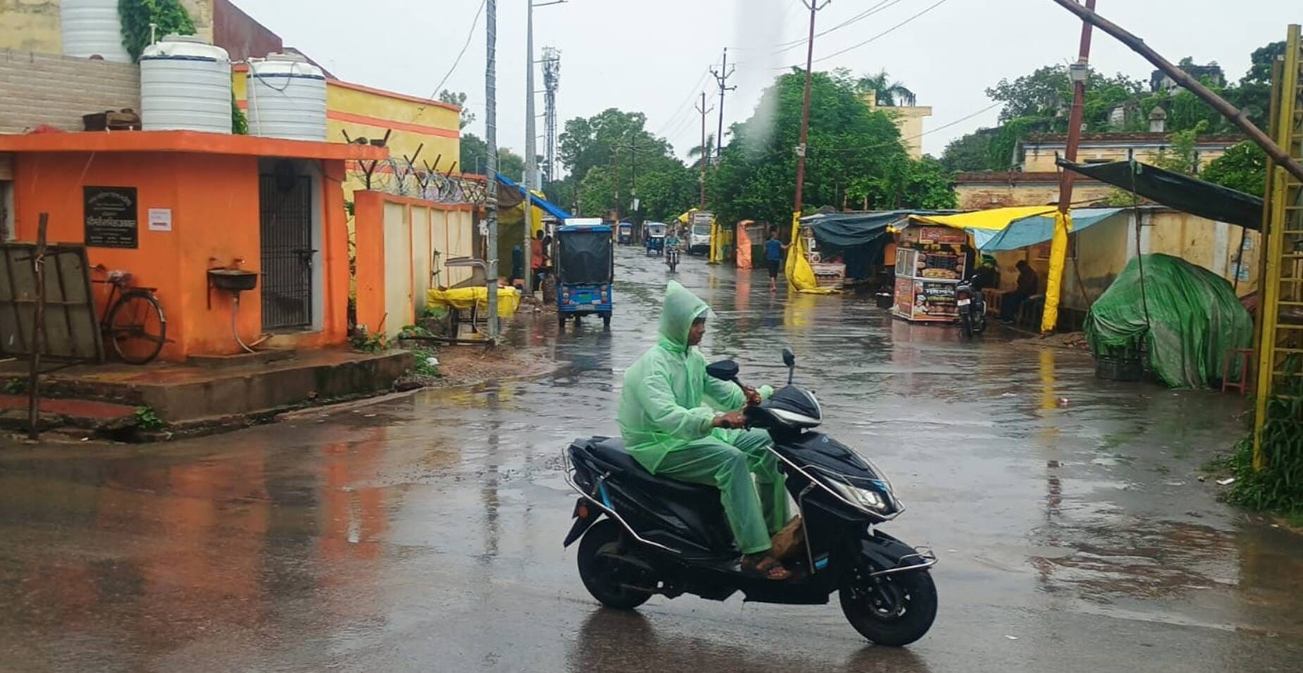 रायफल क्लब सभागार में जलभराव के बीच से निकलते लोग। संवाद रायफल क्लब सभागार में जलभराव के बीच से निकलते लोग। संवाद