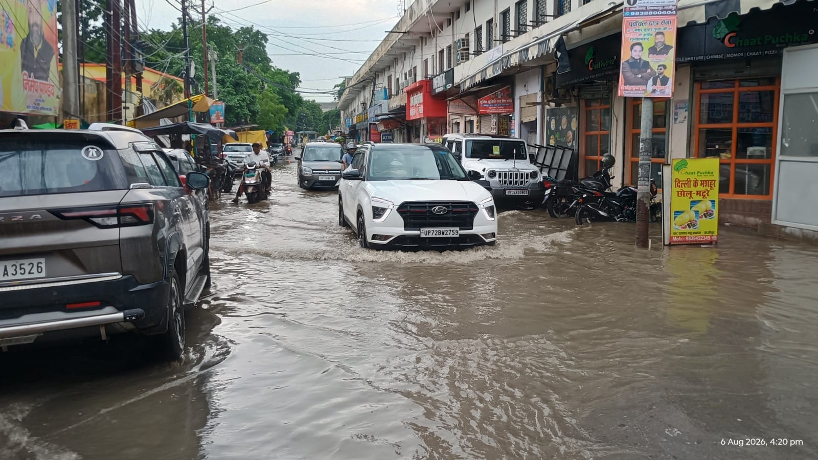 रायफल क्लब सभागार में जलभराव के बीच से निकलते लोग। संवाद रायफल क्लब सभागार में जलभराव के बीच से निकलते लोग। संवाद