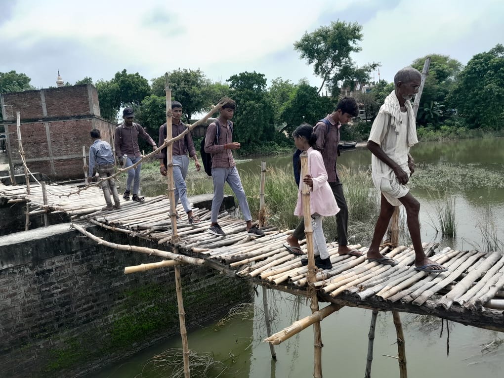 सगड़ी के इस्माइलपुर में सिर पर बोरा लेकर घूटने भर पानी में। संवाद