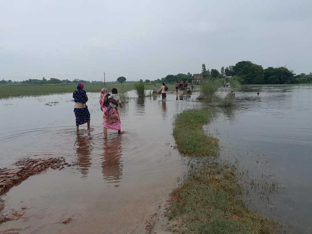 सगड़ी के इस्माइलपुर में सिर पर बोरा लेकर घूटने भर पानी में। संवाद