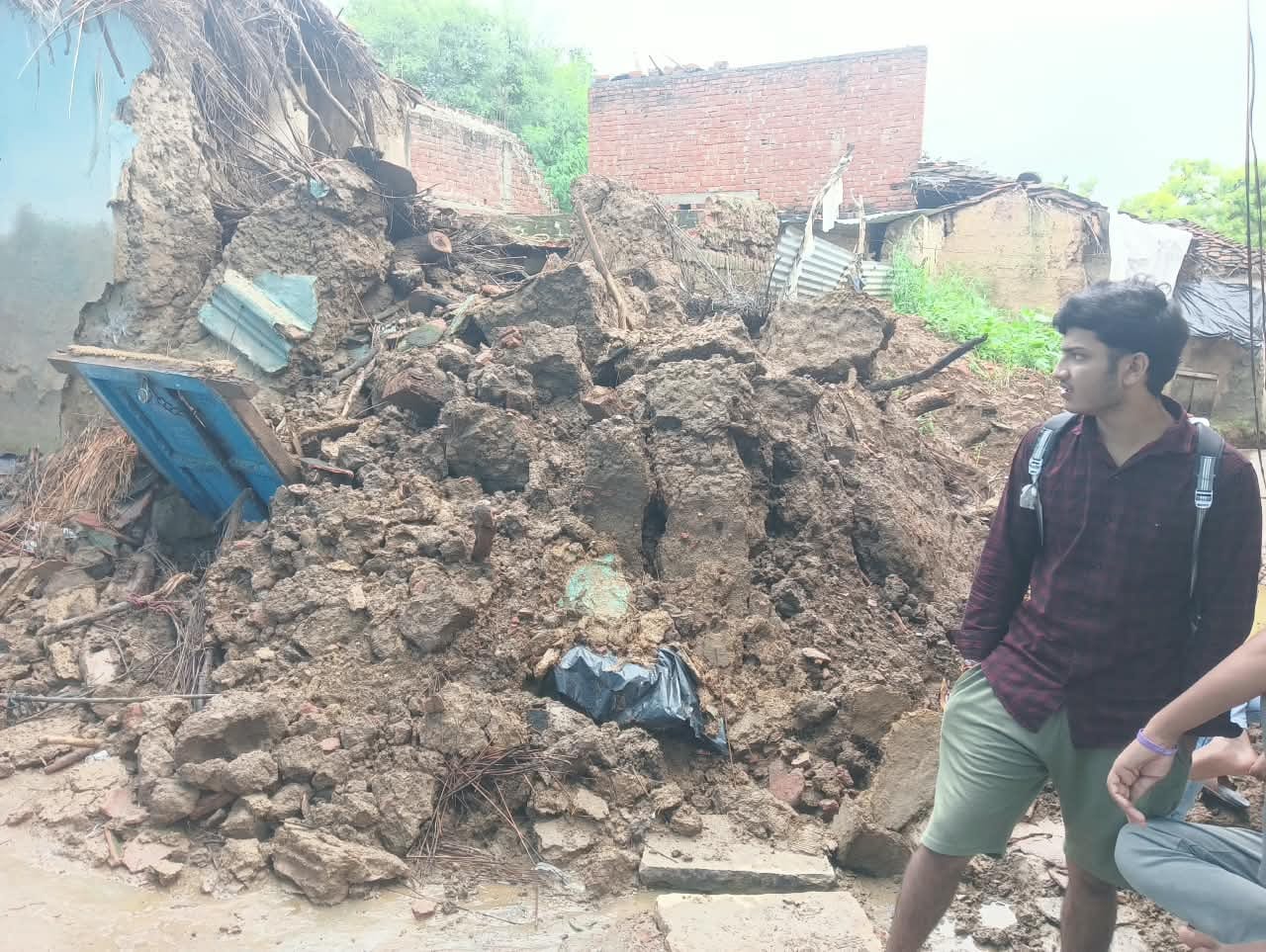 फोटो-10- गांव अमराइया में बारिश से गिरे का मलबा हटाता परिवार का सदस्य। संवाद