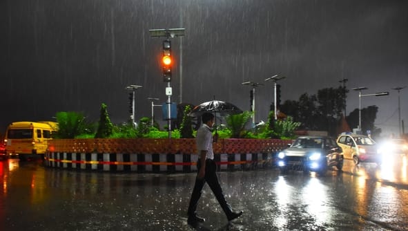 राजधानी में सोमवार शाम बारिश के बीच गुजरते वाहन।