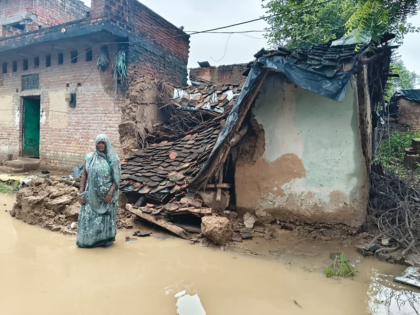 फोटो-20-जल भराव के कारण भदेहदू गांव मे गिरा पक्का मकान। संवाद