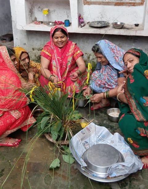गोंडा के जयप्रभाग्राम में हलषष्ठी व्रत पर पूजन के दौरान बेटे को तिलक लगाती मां।