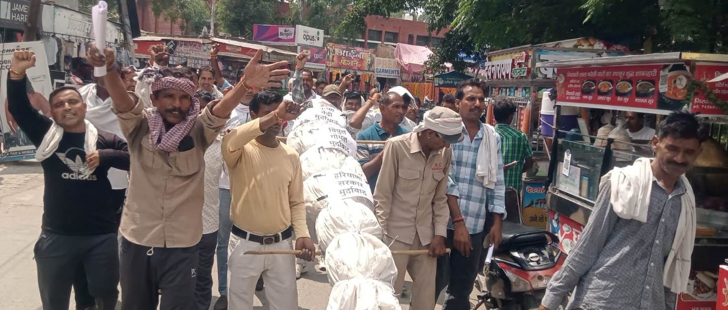 निसिंग पुलिस कर्मचारी सफाई कर्मचारियों को गंदगी के ढेर से हटाते हुए। संवाद