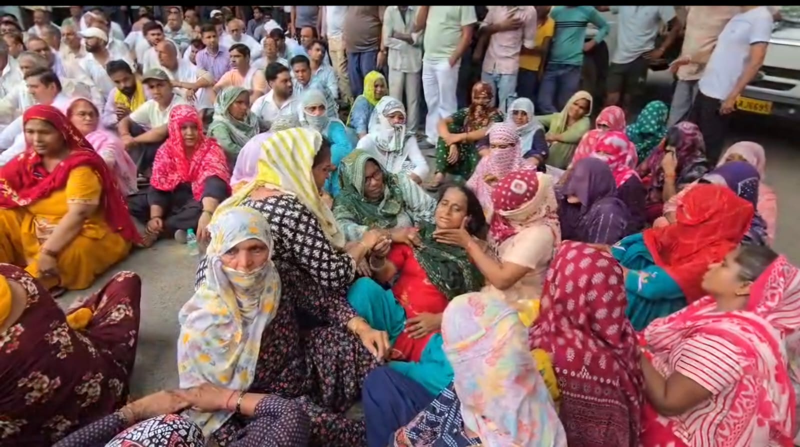 फोटो :: दिल्ली के नरेला में धरने के दौरान प्रमोद के भाई विनोद को गले लगाते डीसीपी शंशाक जायसवाल