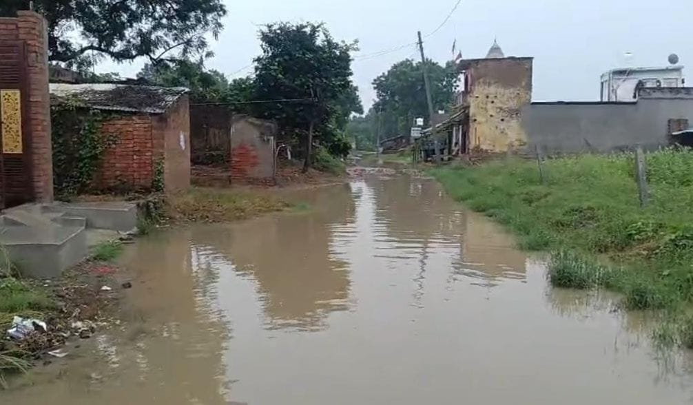 फोटो-24-अढ़ौली गांव में भरे पानी के पास खड़ा युवक। संवाद
