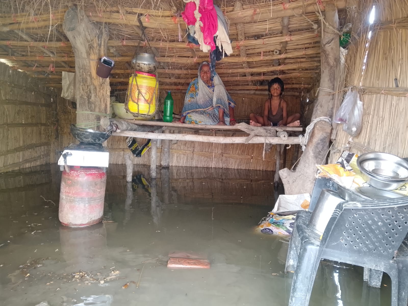 गंगा नदी के बाढ़ के पानी घिरा उमरपुर दियरा गांव स्थित मकान।संवाद