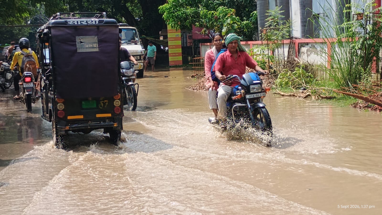 शहर के मिश्रबाजार में सड़क पर जलभराव के बीच गुजरते लोग। संवाद शहर के मिश्रबाजार में सड़क पर जलभराव के बीच गुजरते लोग। संवाद