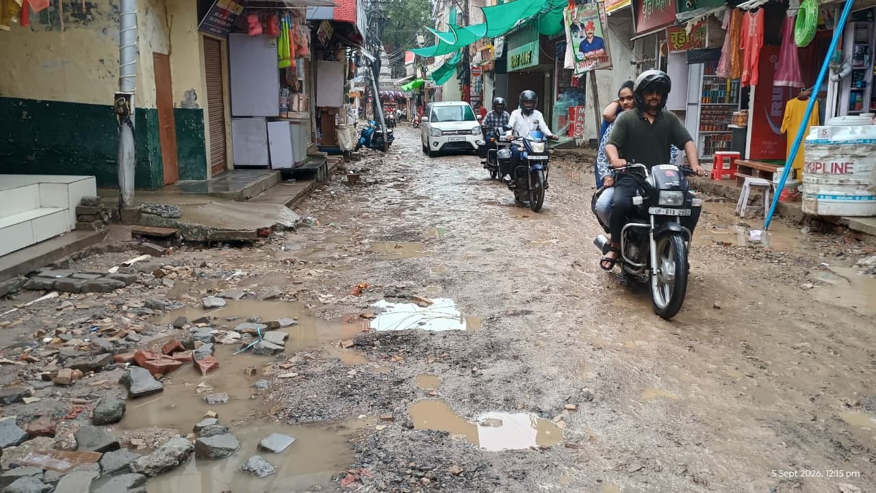 शहर के सिंचाई विभाग चौराहा के पास सड़क पर बने गड्ढों से बचकर निकलते राहगीर। संवाद