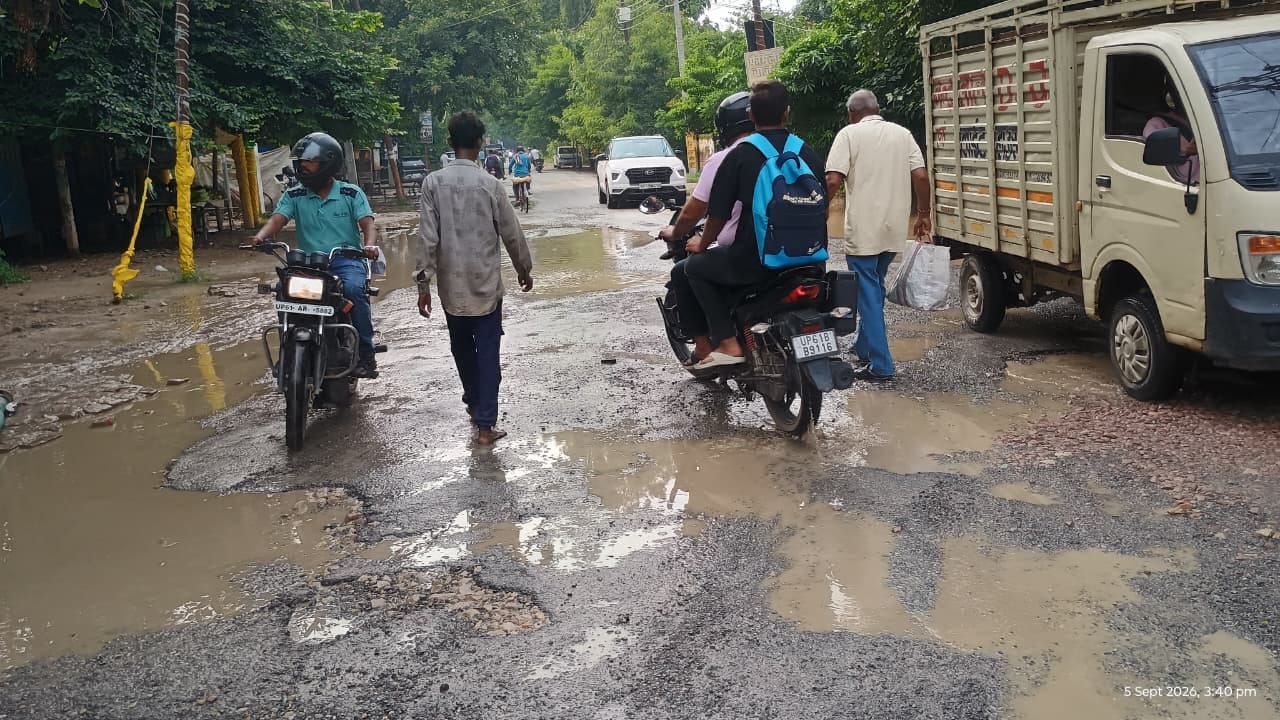 शहर के सिंचाई विभाग चौराहा के पास सड़क पर बने गड्ढों से बचकर निकलते राहगीर। संवाद