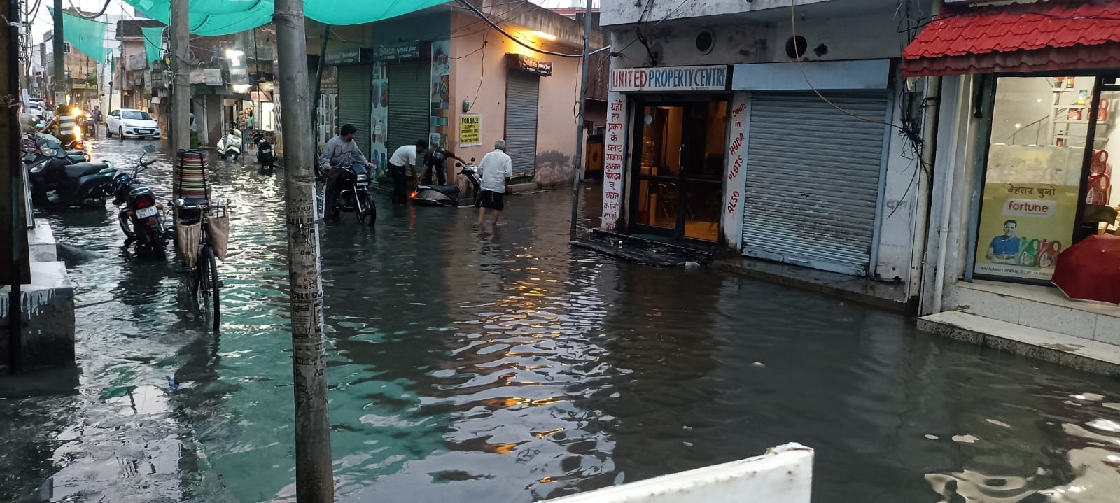 रामनगर में सड़क पर जमा पानी में बंद हुई ई रिक्शा को खींचकर ले जाता चालक। संवाद रामनगर में सड़क पर जमा पानी में बंद हुई ई रिक्शा को खींचकर ले जाता चालक। संवाद