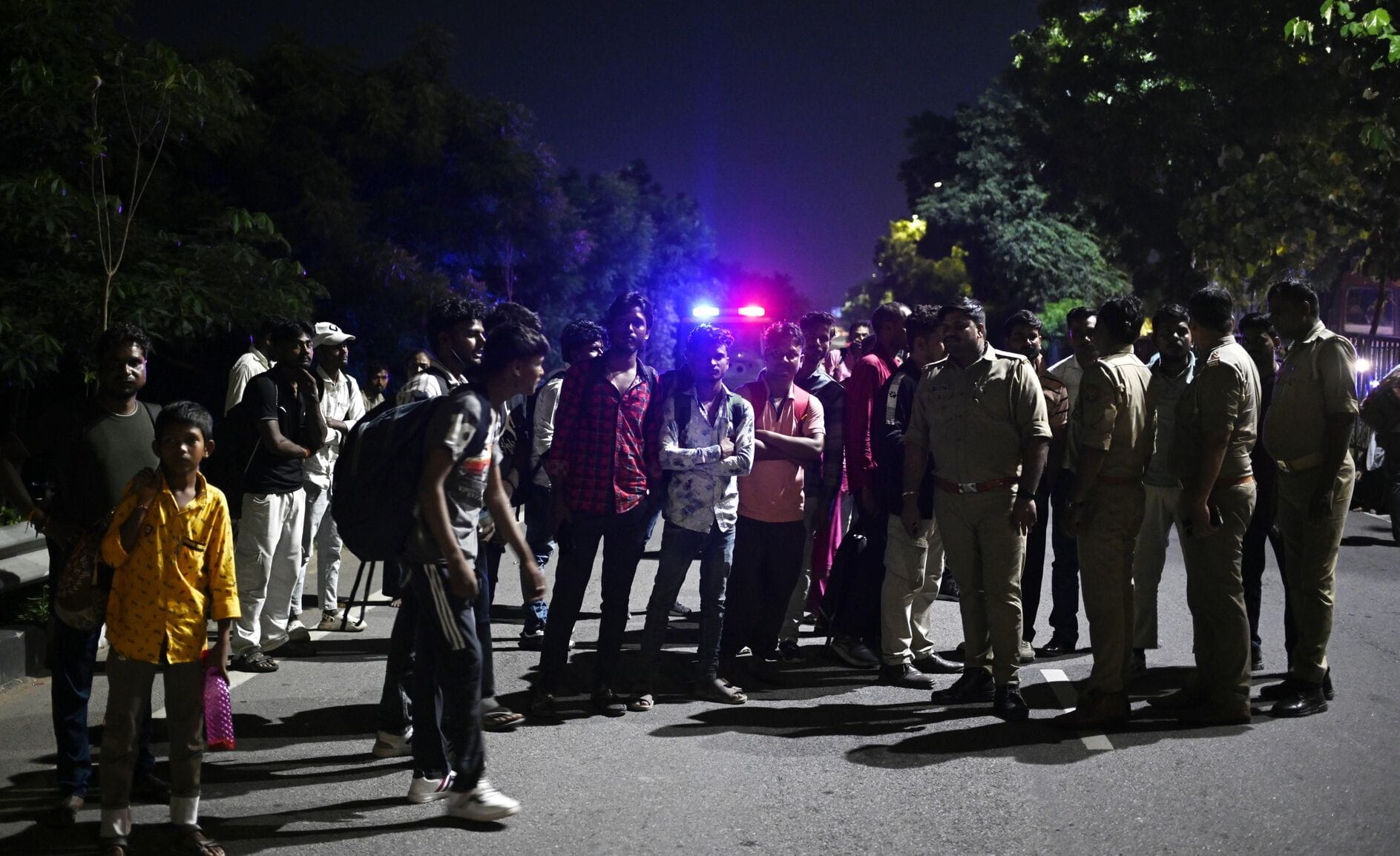 बस में आग लगने के बाद सड़क पर खड़े यात्री