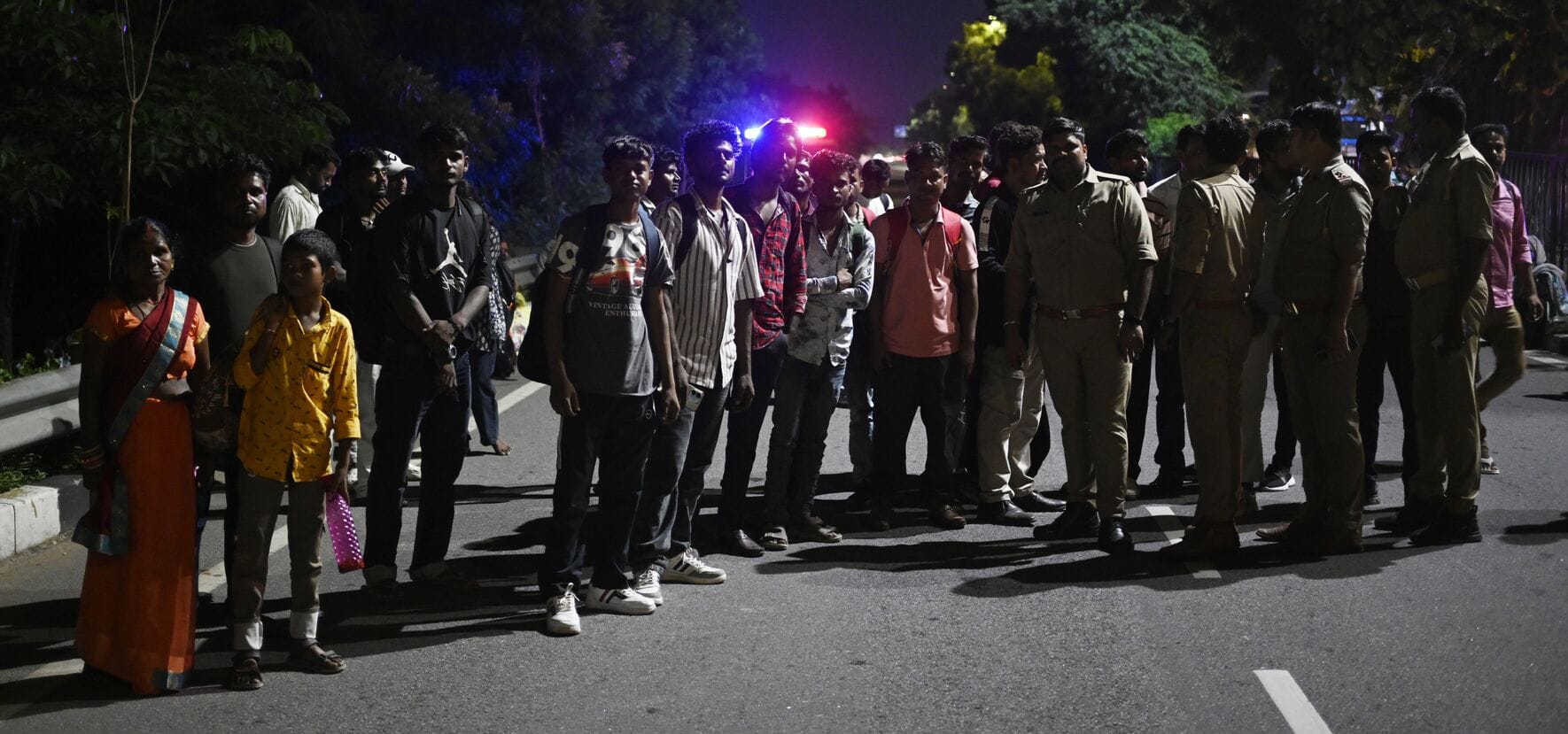 बस में आग लगने के बाद सड़क पर खड़े यात्री
