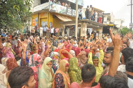 गांव बदनौली में हापुड़ मोदीनगर रोड पर सड़क पर बैठे लोग। संवाद गांव बदनौली में हापुड़ मोदीनगर रोड पर सड़क पर बैठे लोग। संवाद