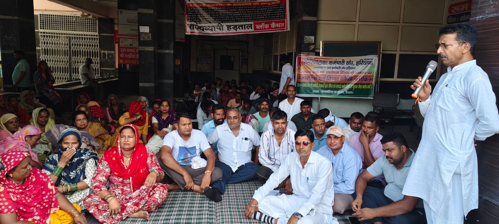 नगर परिषद कार्यालय परिसर में धरने पर बैठे कर्मचारी। संवाद