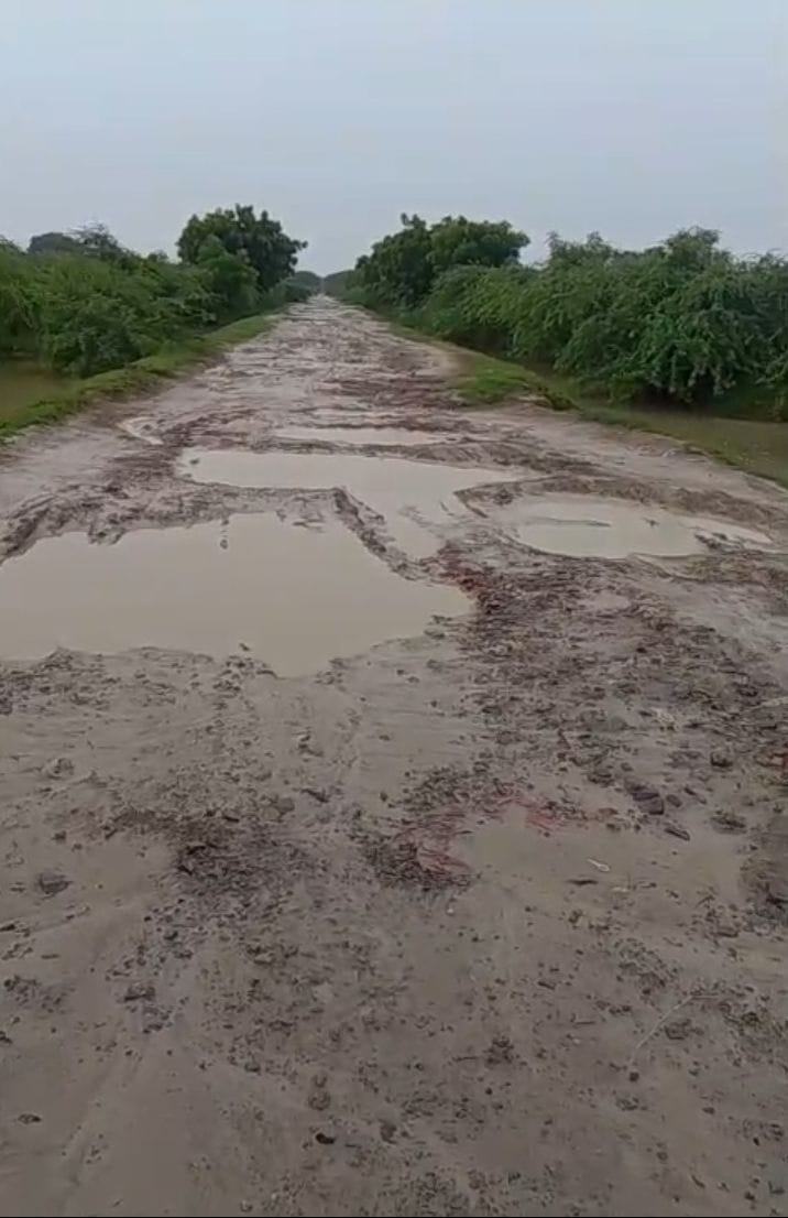 धरना देते किसान व जर्जर सड़क। धरना देते किसान व जर्जर सड़क।