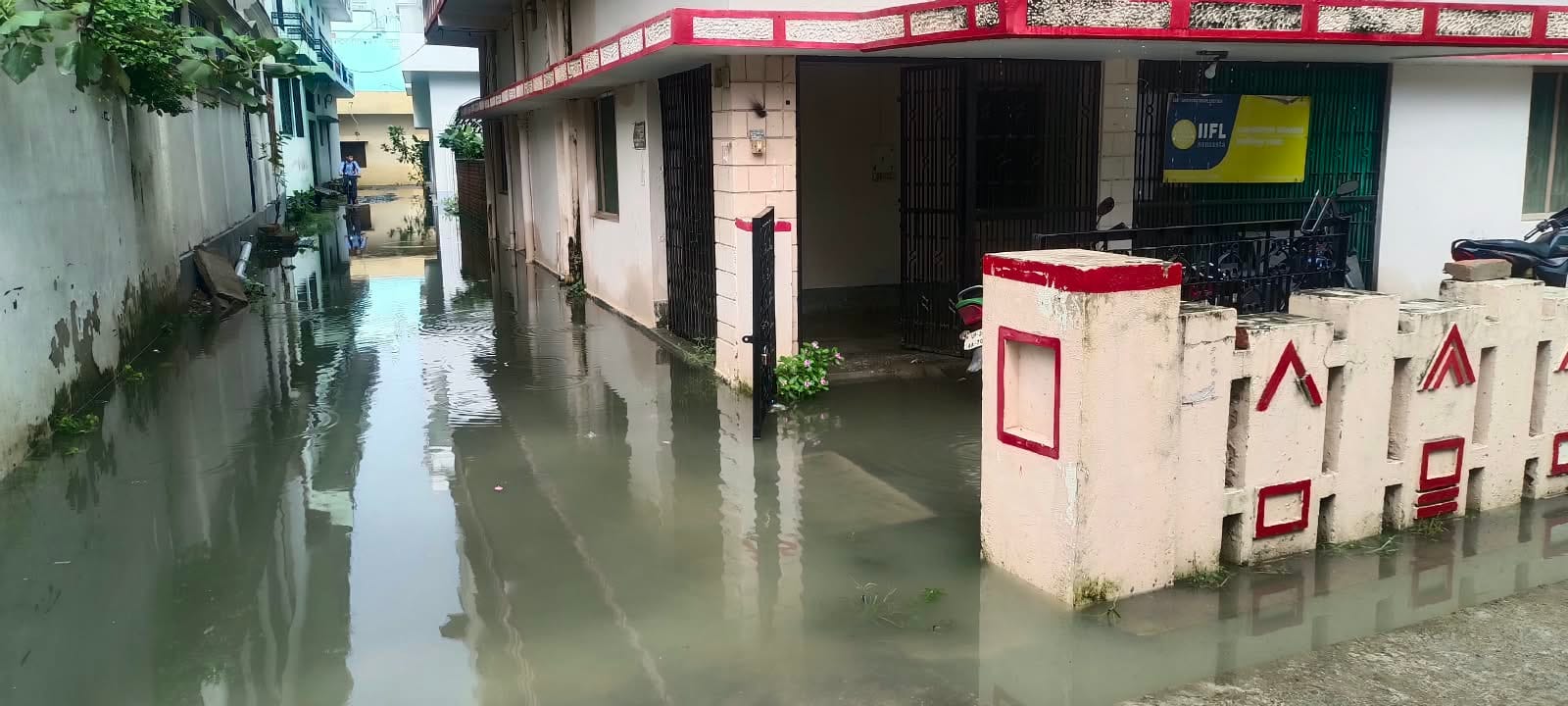 जलभराव के बीच निकलते स्कूली बच्चे व राहगीर। संवाद
