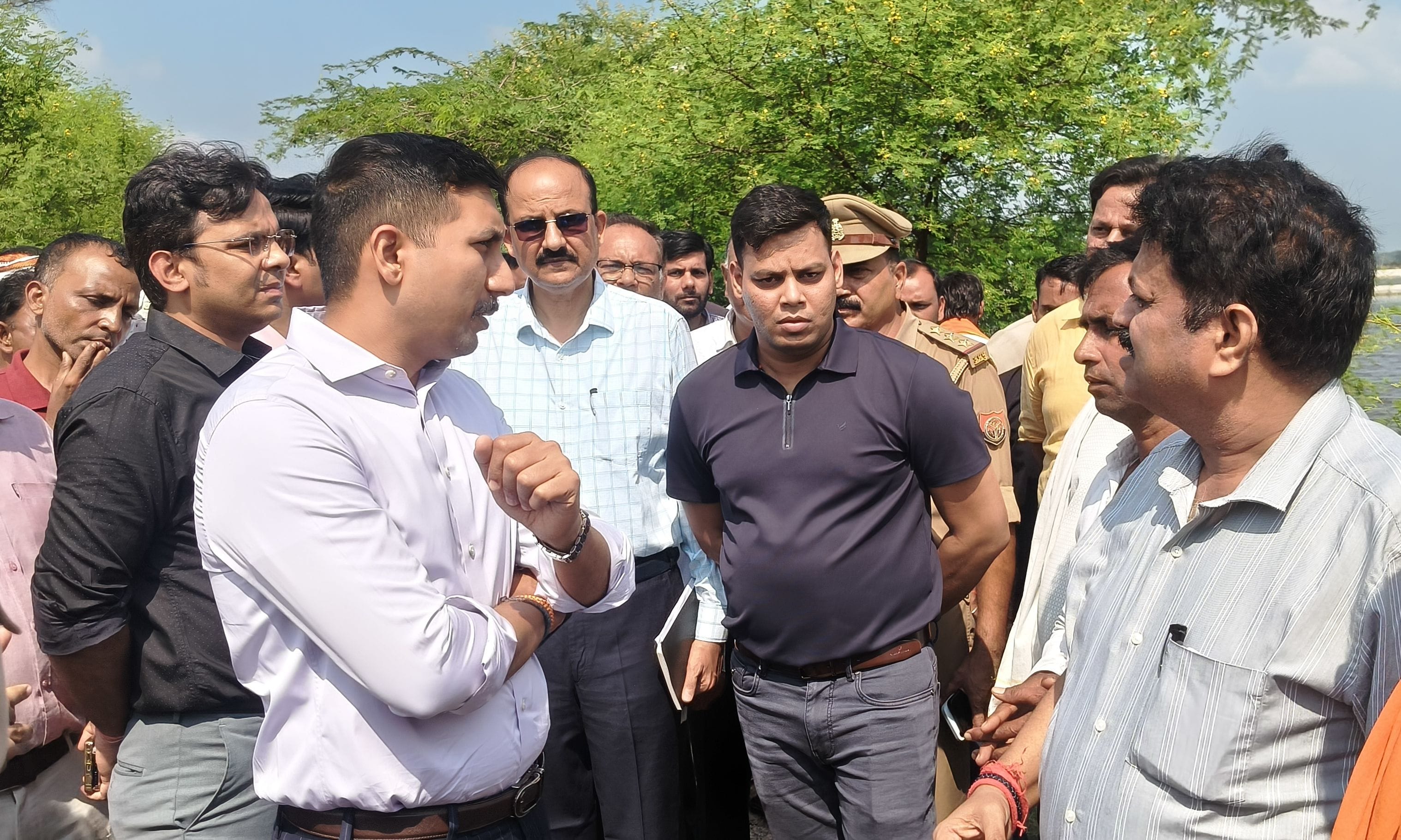 बाढ़ के बीच से जातीं छात्राएं और अधिकारियों को निर्देश देते डीएम।