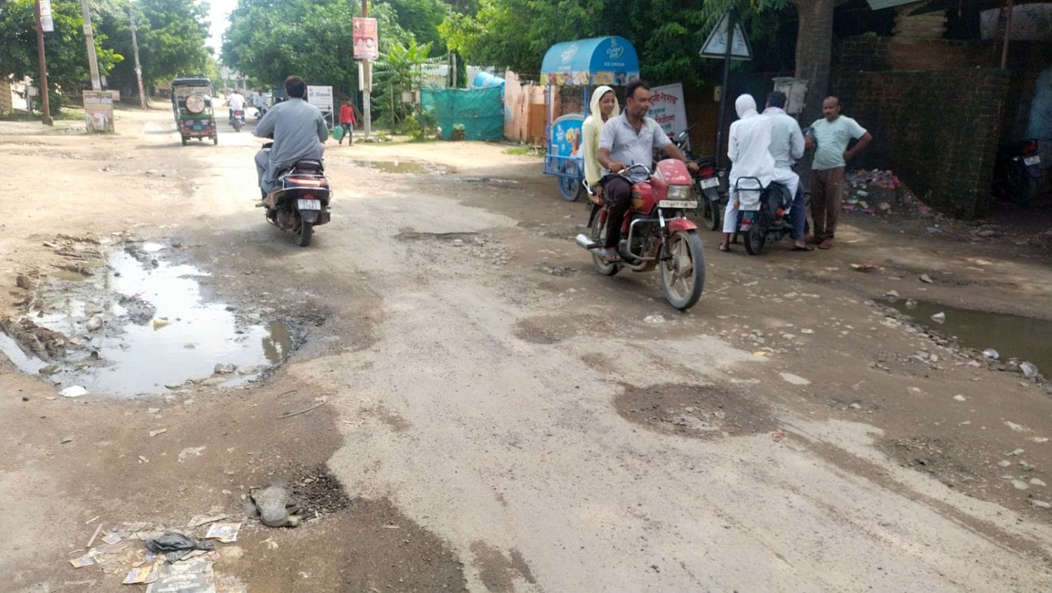 फोटो 12 एमएएचपी 14 परिचय-गड्ढों में तब्दील झलकारीबाई तिराहे से स्टेशन मार्ग की सड़क से गुजरते व फोटो 12 एमएएचपी 14 परिचय-गड्ढों में तब्दील झलकारीबाई तिराहे से स्टेशन मार्ग की सड़क से गुजरते व