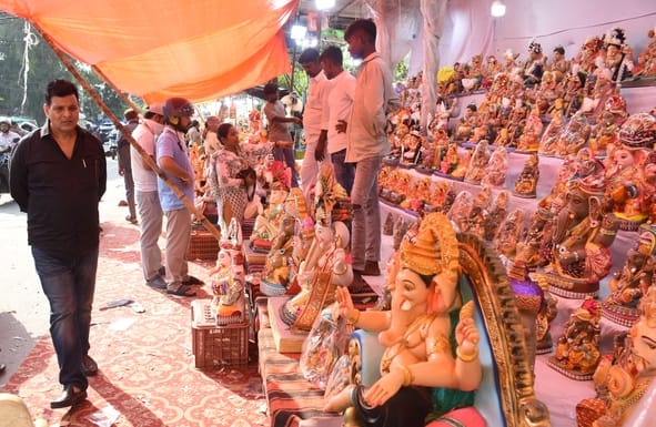जानकारी देते गणेश प्राकट्य कमेटी के पदाधिकारी व गणपति की प्रतिमा खरीदकर घर ले जाते श्रद्धालु।