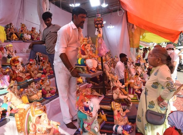 जानकारी देते गणेश प्राकट्य कमेटी के पदाधिकारी व गणपति की प्रतिमा खरीदकर घर ले जाते श्रद्धालु।