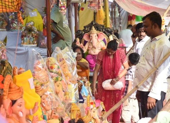 जानकारी देते गणेश प्राकट्य कमेटी के पदाधिकारी व गणपति की प्रतिमा खरीदकर घर ले जाते श्रद्धालु।