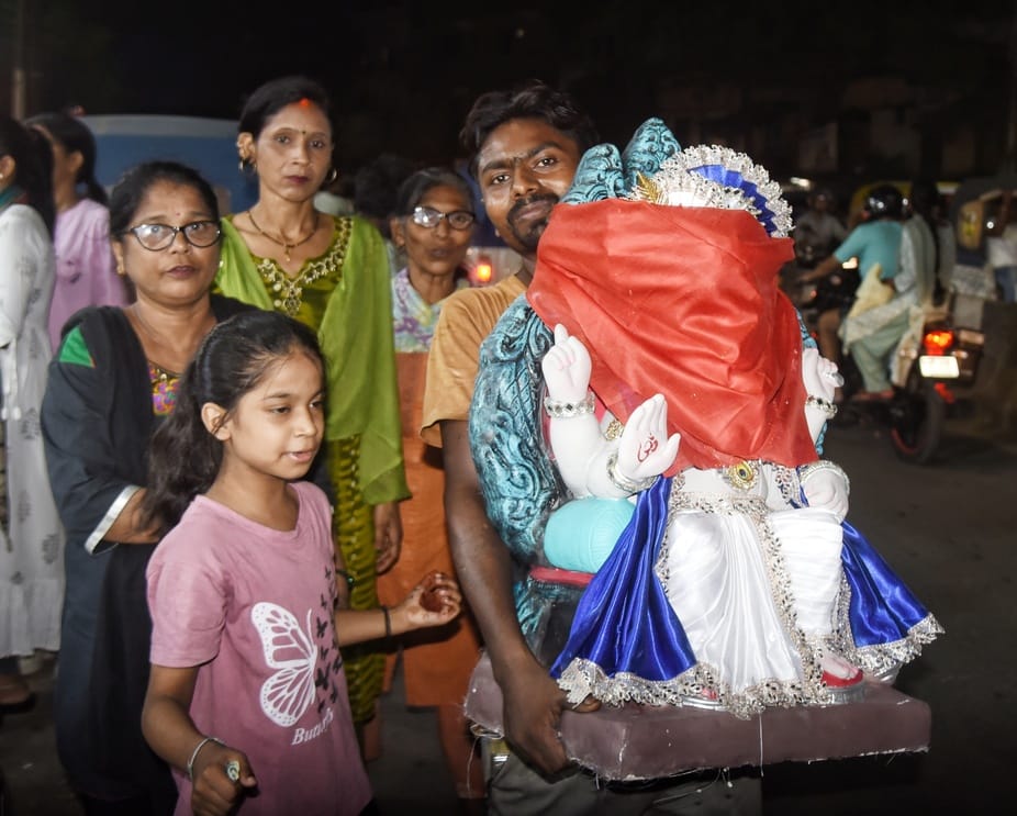 जानकारी देते गणेश प्राकट्य कमेटी के पदाधिकारी व गणपति की प्रतिमा खरीदकर घर ले जाते श्रद्धालु।