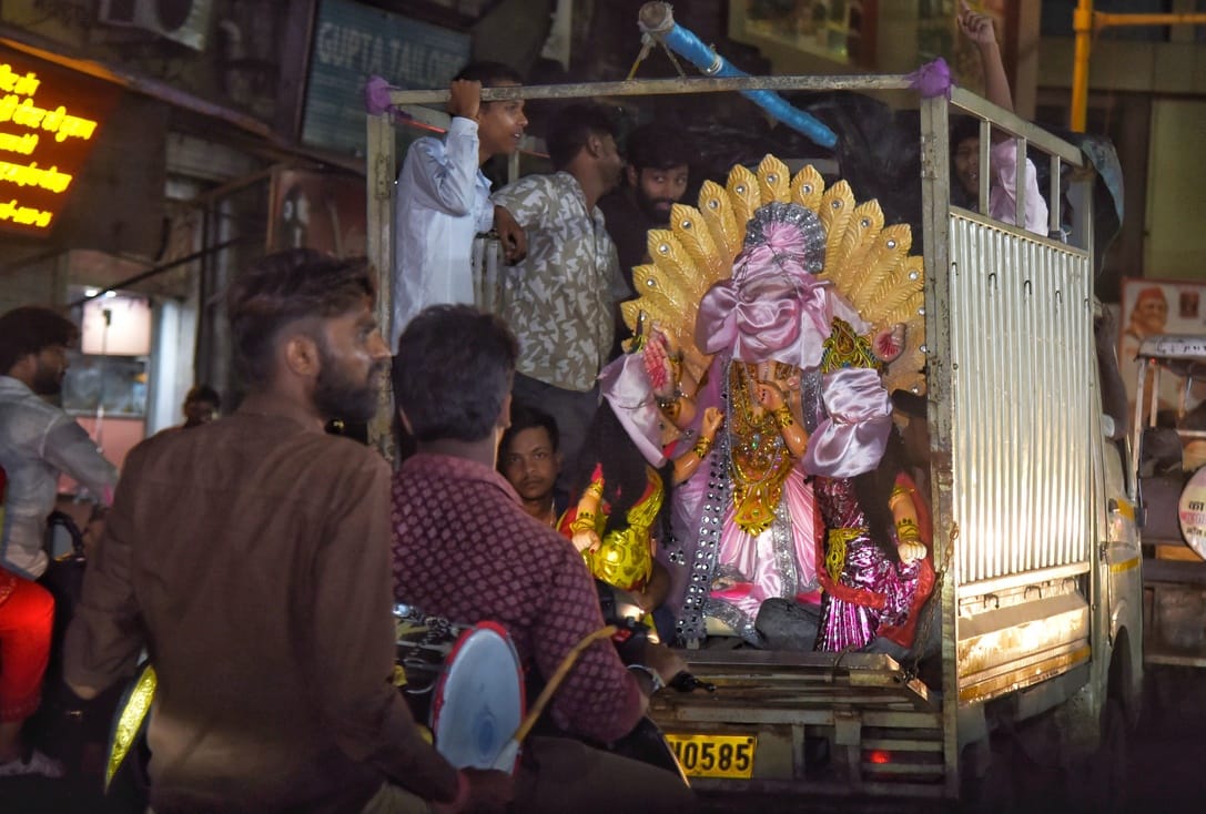 जानकारी देते गणेश प्राकट्य कमेटी के पदाधिकारी व गणपति की प्रतिमा खरीदकर घर ले जाते श्रद्धालु।