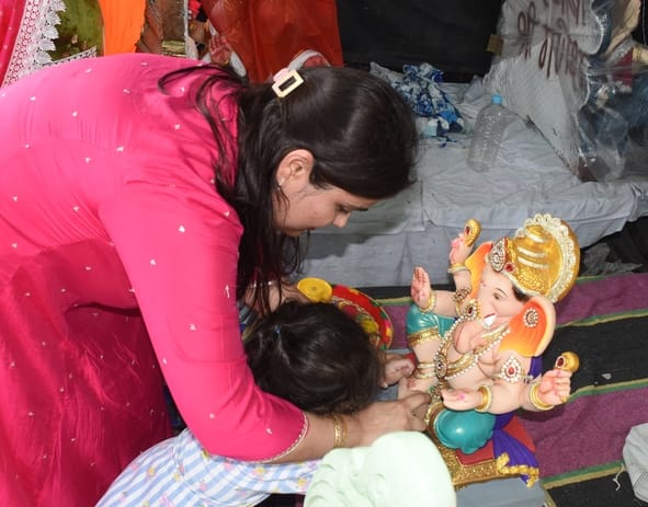 जानकारी देते गणेश प्राकट्य कमेटी के पदाधिकारी व गणपति की प्रतिमा खरीदकर घर ले जाते श्रद्धालु।