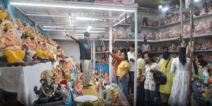जानकारी देते गणेश प्राकट्य कमेटी के पदाधिकारी व गणपति की प्रतिमा खरीदकर घर ले जाते श्रद्धालु।