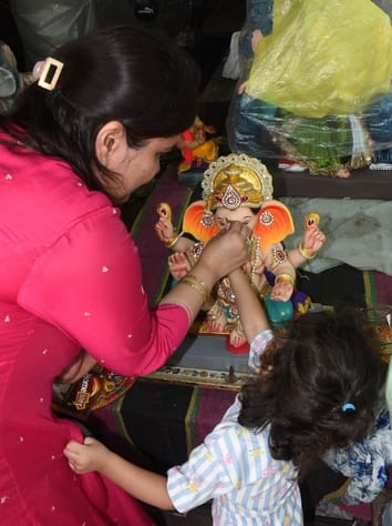 जानकारी देते गणेश प्राकट्य कमेटी के पदाधिकारी व गणपति की प्रतिमा खरीदकर घर ले जाते श्रद्धालु।