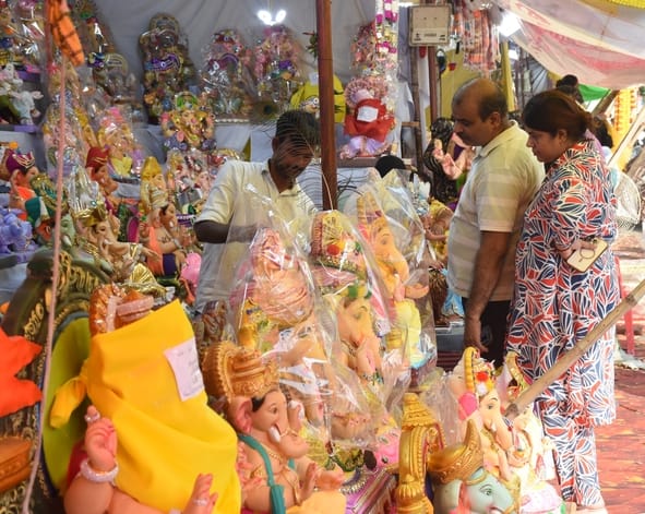 जानकारी देते गणेश प्राकट्य कमेटी के पदाधिकारी व गणपति की प्रतिमा खरीदकर घर ले जाते श्रद्धालु।