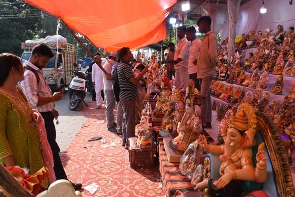 जानकारी देते गणेश प्राकट्य कमेटी के पदाधिकारी व गणपति की प्रतिमा खरीदकर घर ले जाते श्रद्धालु।