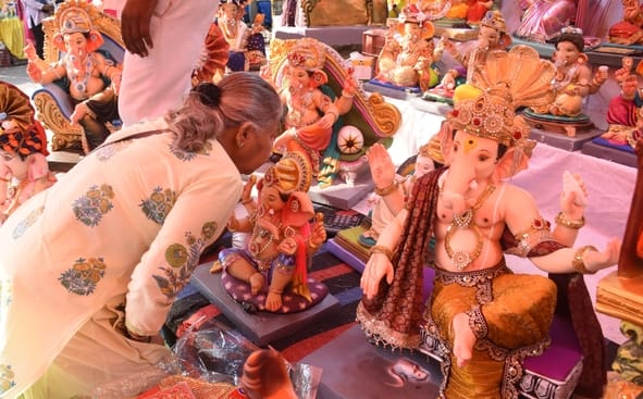 जानकारी देते गणेश प्राकट्य कमेटी के पदाधिकारी व गणपति की प्रतिमा खरीदकर घर ले जाते श्रद्धालु।