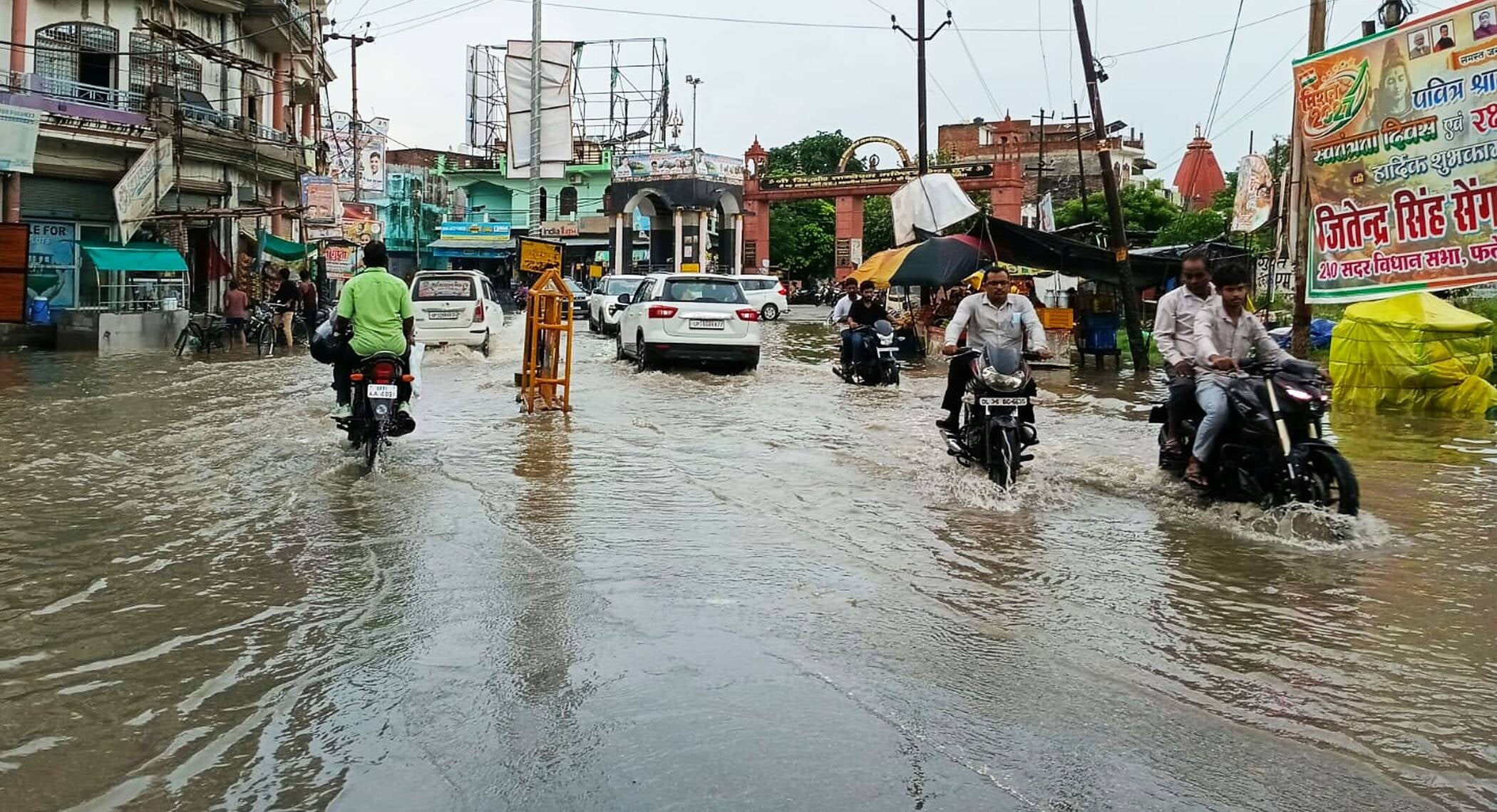 फोटो-45-जिला अस्पताल के पास सड़क पर भरे पानी से निकलते वाहन। संवाद