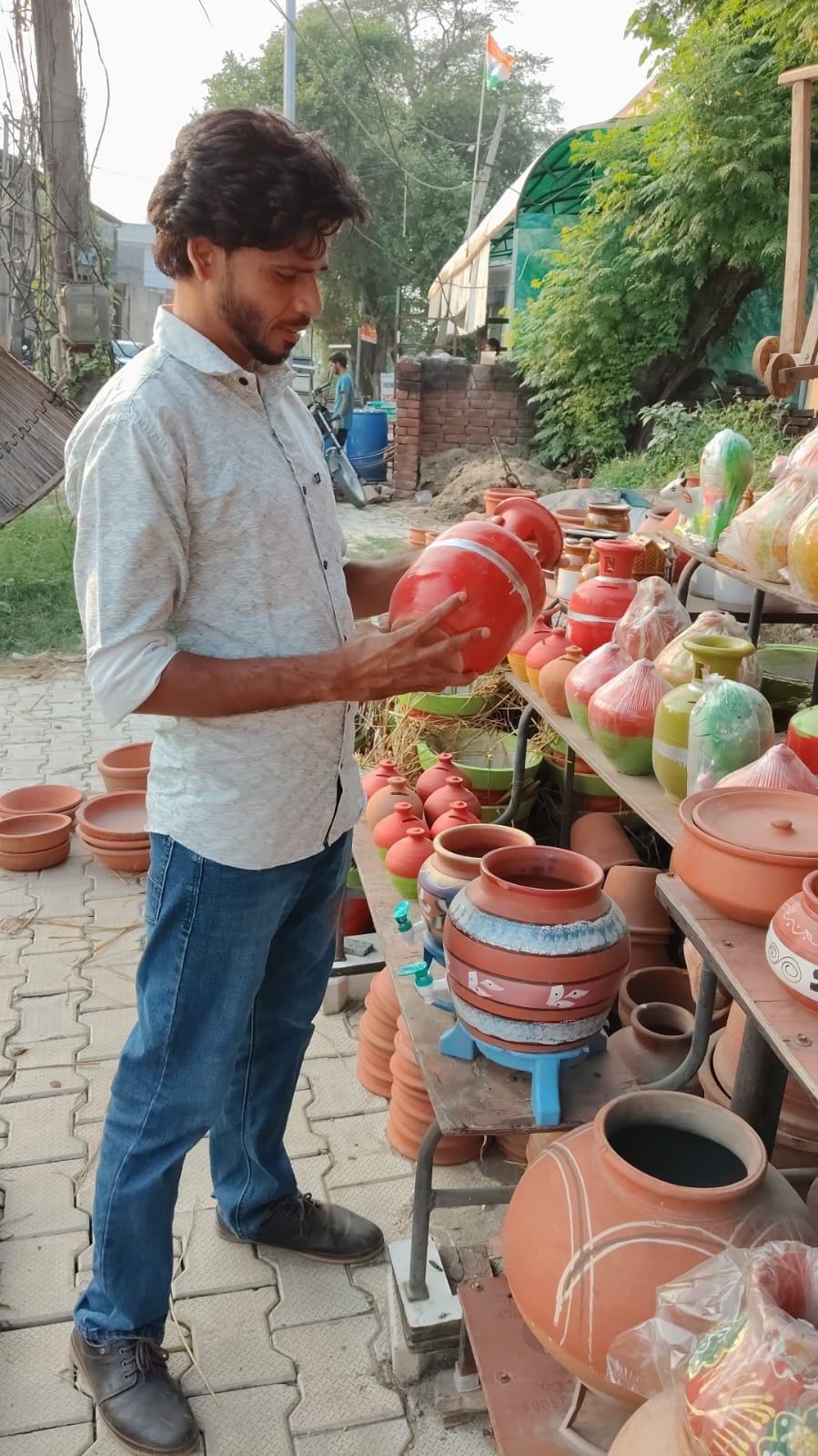 मिट्टी से बने बर्तन पसंद करता युवक। संवाद मिट्टी से बने बर्तन पसंद करता युवक। संवाद