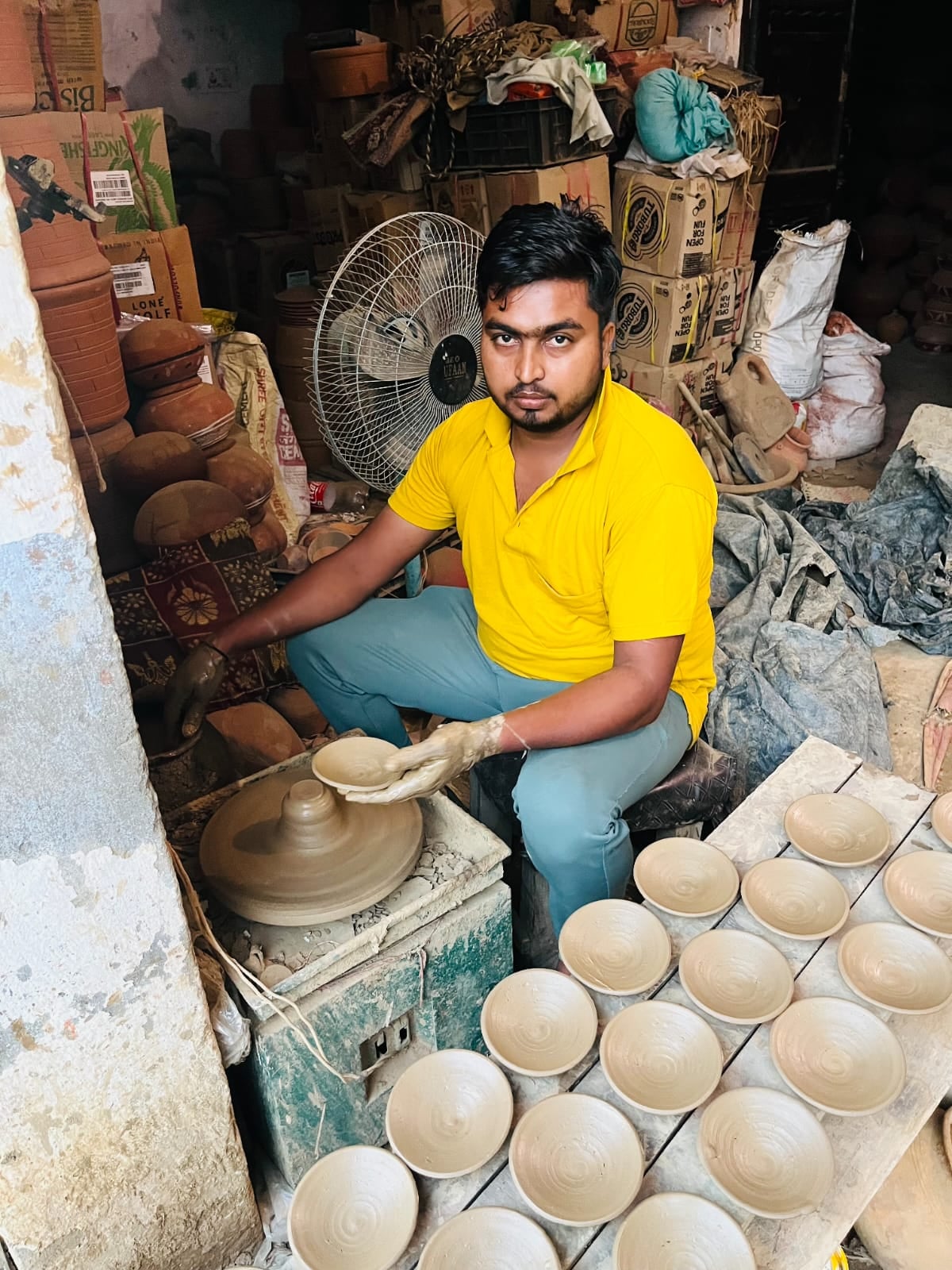 मिट्टी से बने बर्तन पसंद करता युवक। संवाद मिट्टी से बने बर्तन पसंद करता युवक। संवाद
