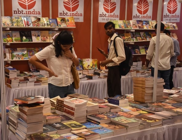लविवि में लगे गोमती पुस्तक मेले में पुस्तकें देखते हुए लोग। 