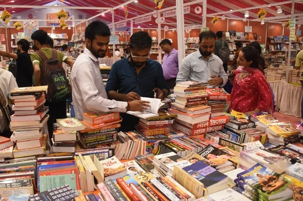 लविवि में लगे गोमती पुस्तक मेले में पुस्तकें देखते हुए लोग। 