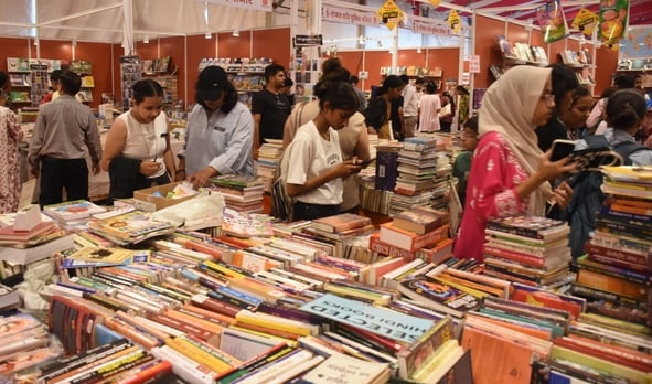 लविवि में लगे गोमती पुस्तक मेले में पुस्तकें देखते हुए लोग। 