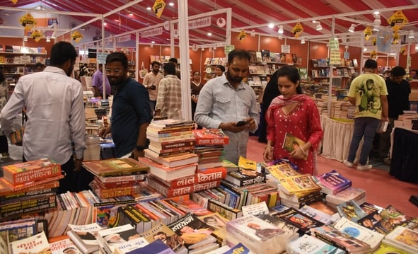 लविवि में लगे गोमती पुस्तक मेले में पुस्तकें देखते हुए लोग। 