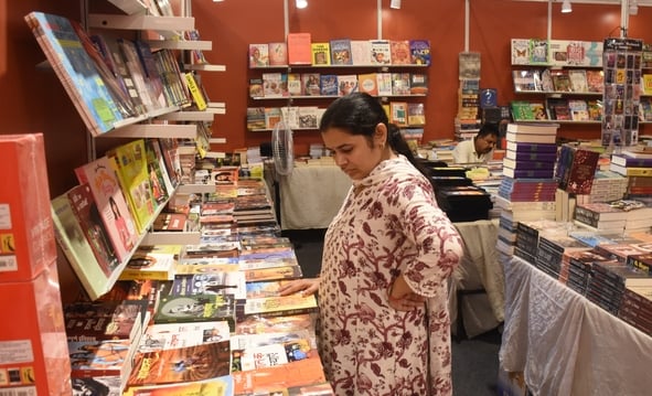 लविवि में लगे गोमती पुस्तक मेले में पुस्तकें देखते हुए लोग। 
