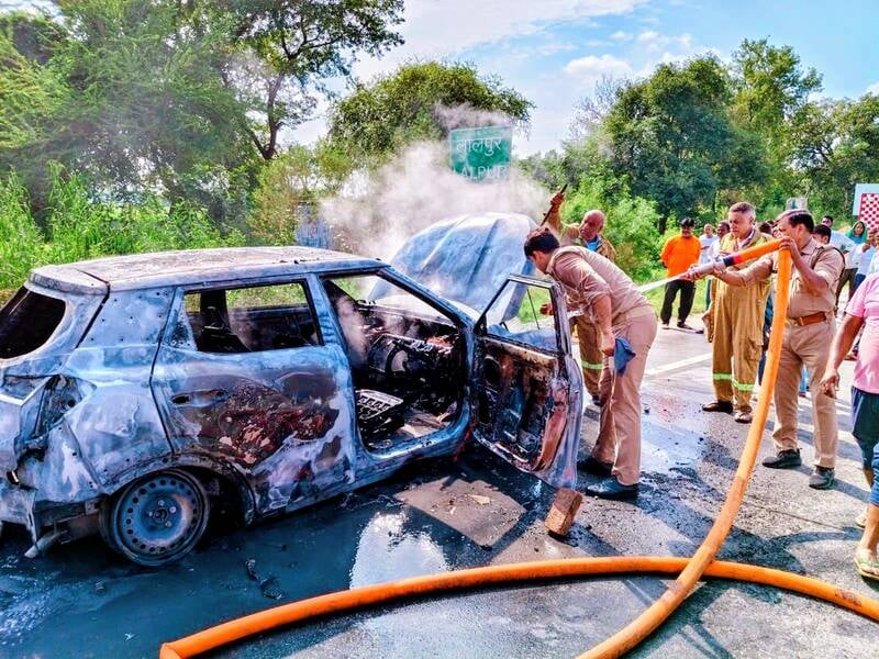 एसयूवी में लगी आग और उसे बुझाते दमकलकर्मी एसयूवी में लगी आग और उसे बुझाते दमकलकर्मी