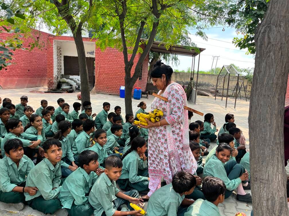 मिड डे मील नहीं पकने पर बच्चों को केले वितरित करते हुए शिक्षिका। संवाद मिड डे मील नहीं पकने पर बच्चों को केले वितरित करते हुए शिक्षिका। संवाद
