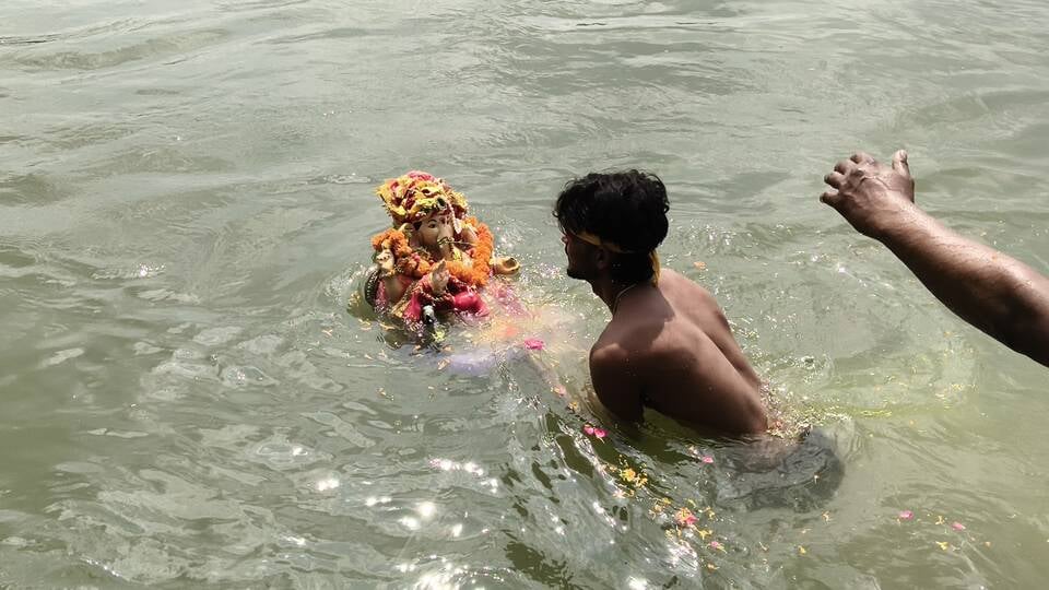 विसर्जन करने से पहले गणेश के कान में मन्नत बताती छोटी बच्ची। अशोक कुमार विसर्जन करने से पहले गणेश के कान में मन्नत बताती छोटी बच्ची। अशोक कुमार