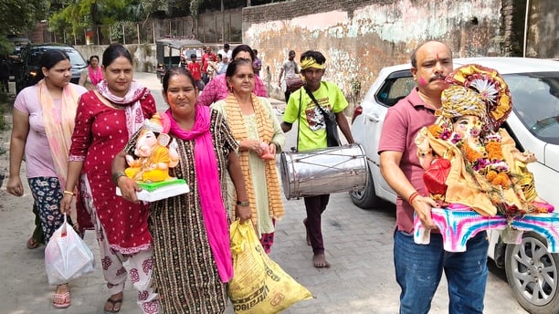 विसर्जन करने से पहले गणेश के कान में मन्नत बताती छोटी बच्ची। अशोक कुमार विसर्जन करने से पहले गणेश के कान में मन्नत बताती छोटी बच्ची। अशोक कुमार