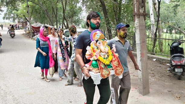 विसर्जन करने से पहले गणेश के कान में मन्नत बताती छोटी बच्ची। अशोक कुमार विसर्जन करने से पहले गणेश के कान में मन्नत बताती छोटी बच्ची। अशोक कुमार