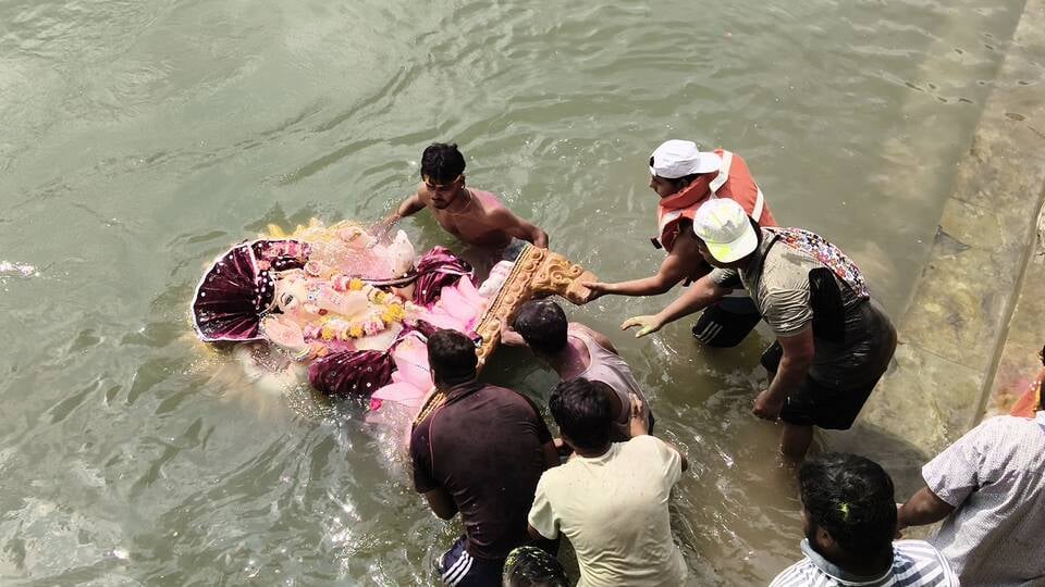 विसर्जन करने से पहले गणेश के कान में मन्नत बताती छोटी बच्ची। अशोक कुमार विसर्जन करने से पहले गणेश के कान में मन्नत बताती छोटी बच्ची। अशोक कुमार